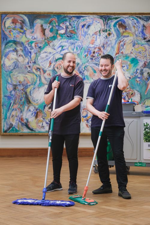 schoonmakers poseren met dweil