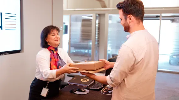 Hospitality host geeft pakje aan klant