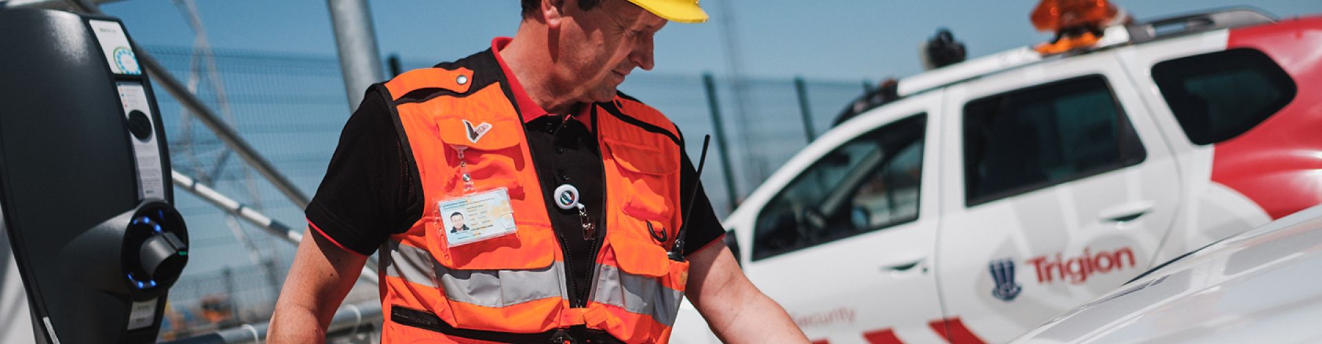 Man met gele helm tankt elektrische auto van Trigion