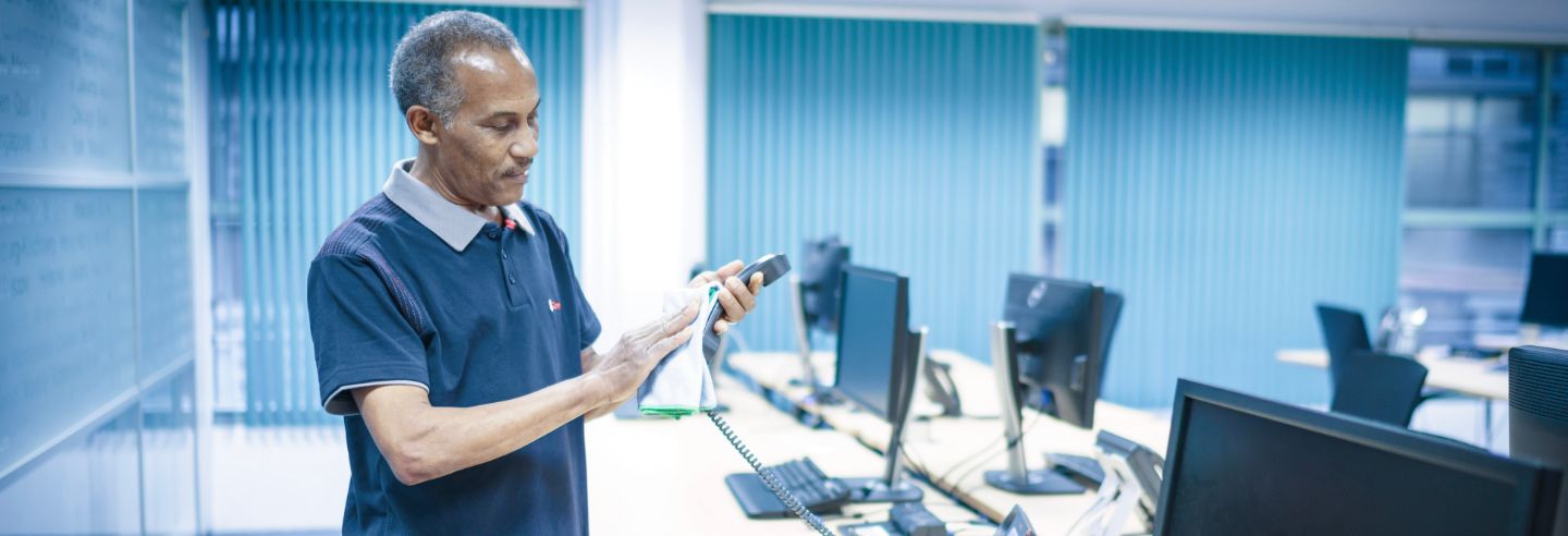 homme nettoyant le récepteur d'un téléphone