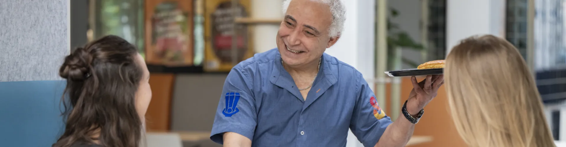 chef bedient twee gasten met een glimlach