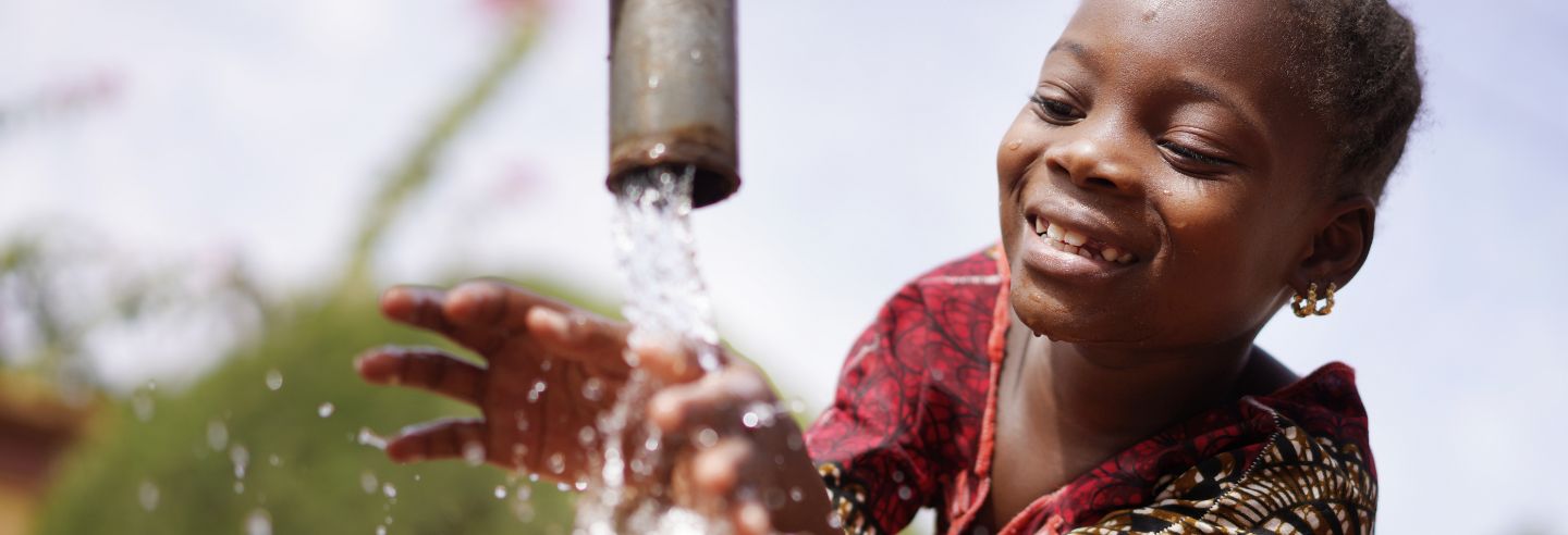 kindje speelt met water uit kraan