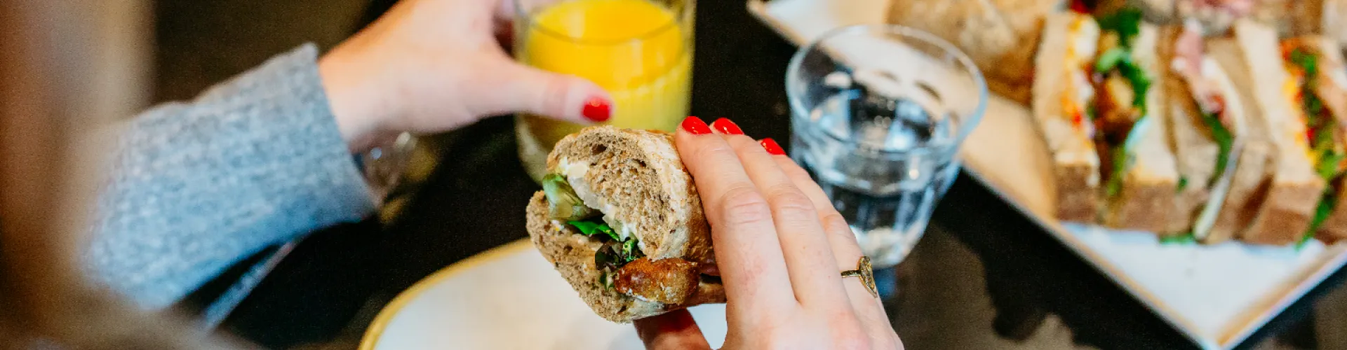 broodje en glas fruitsap in de hand