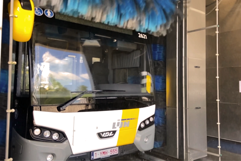 Een De Lijn bus rijdt door een carwash