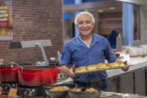 Chef poseert glimlachend met plateau broodjes