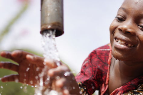 kindje speelt met water uit kraan