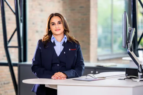 jonge vrouw poseert lachend achter balie